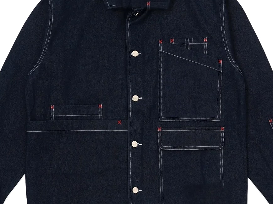 Chest, placket and patch pocket of an indigo denim work jacket
