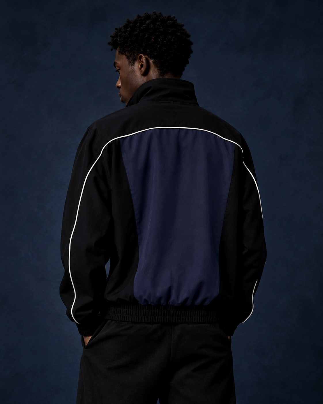 Back view of the navy track jacket worn on body
