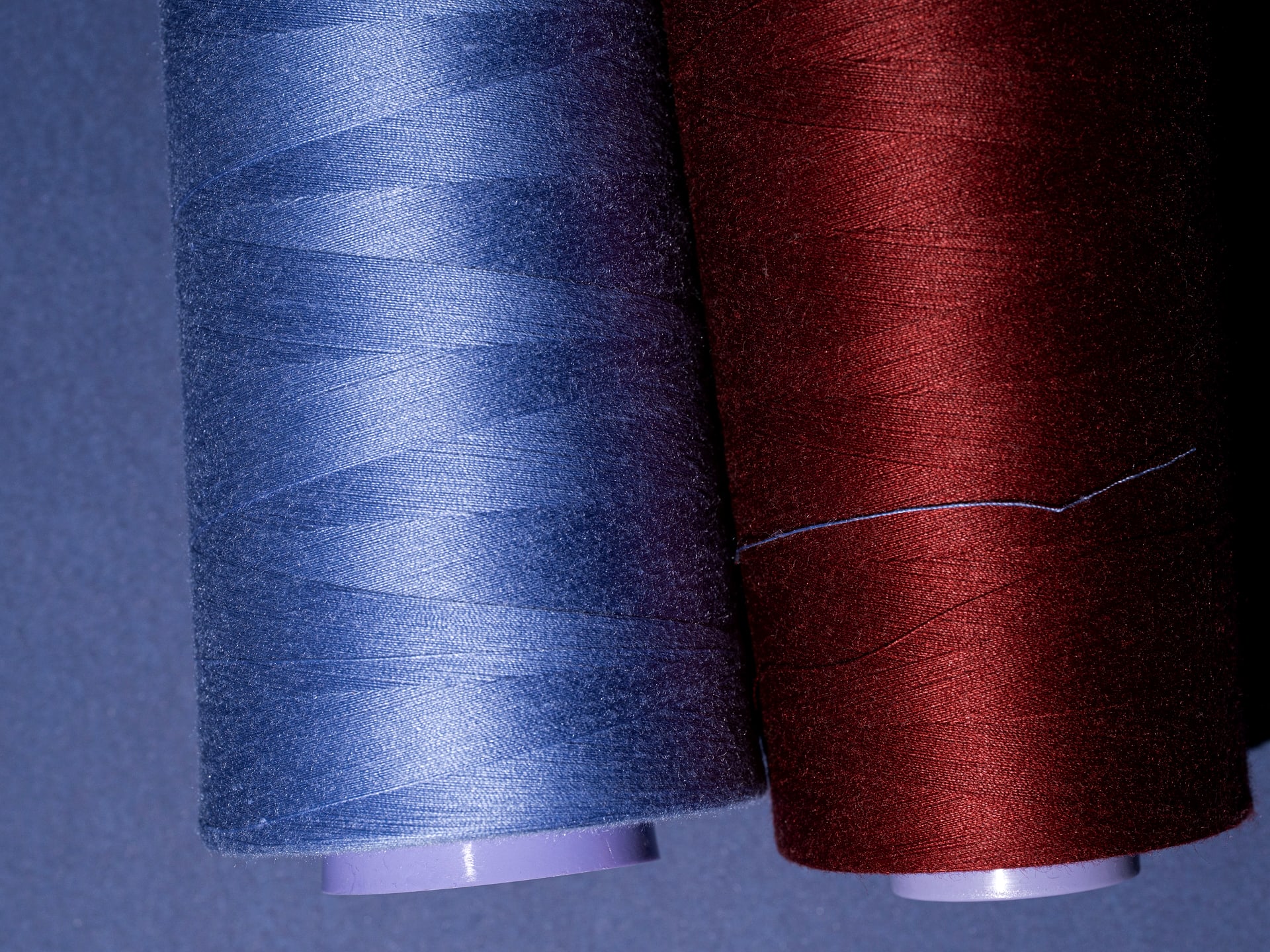 A second pair of yarn cones, blue and burgundy, in a darker colourway