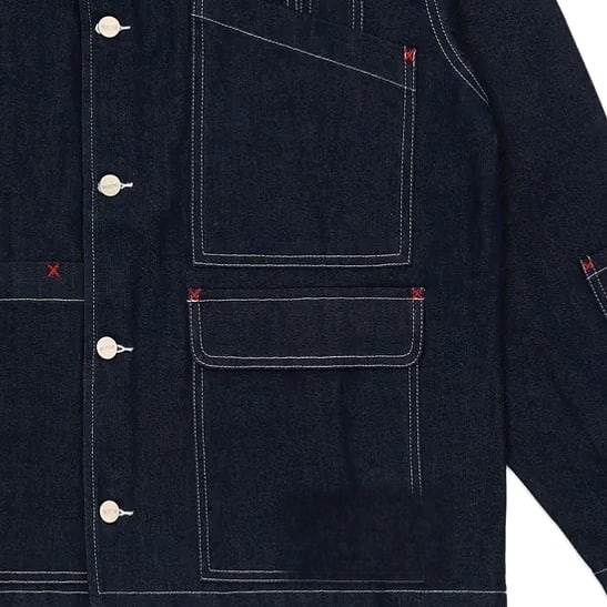 Red bartacks and contrast topstitching at a denim pocket flap