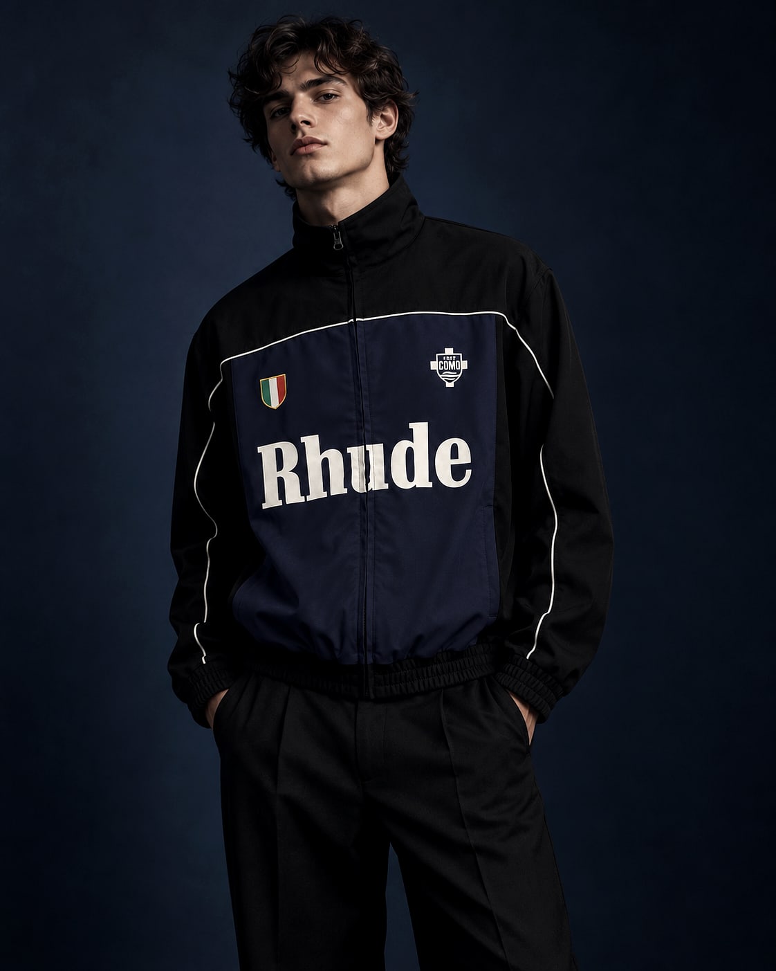 Model wearing the navy panelled track jacket from a delivered fashion and football collaboration